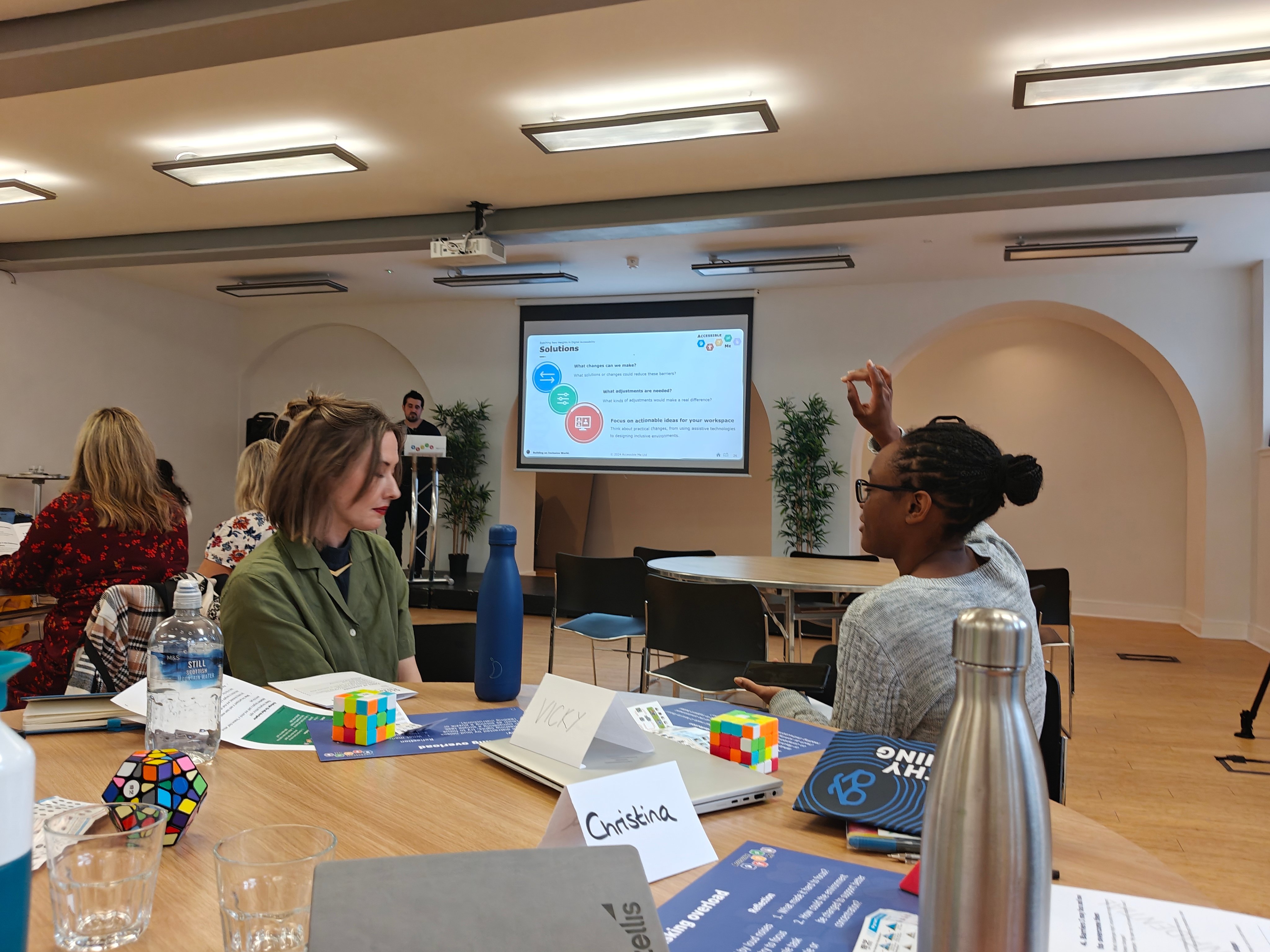A participant raising their hand to ask a question