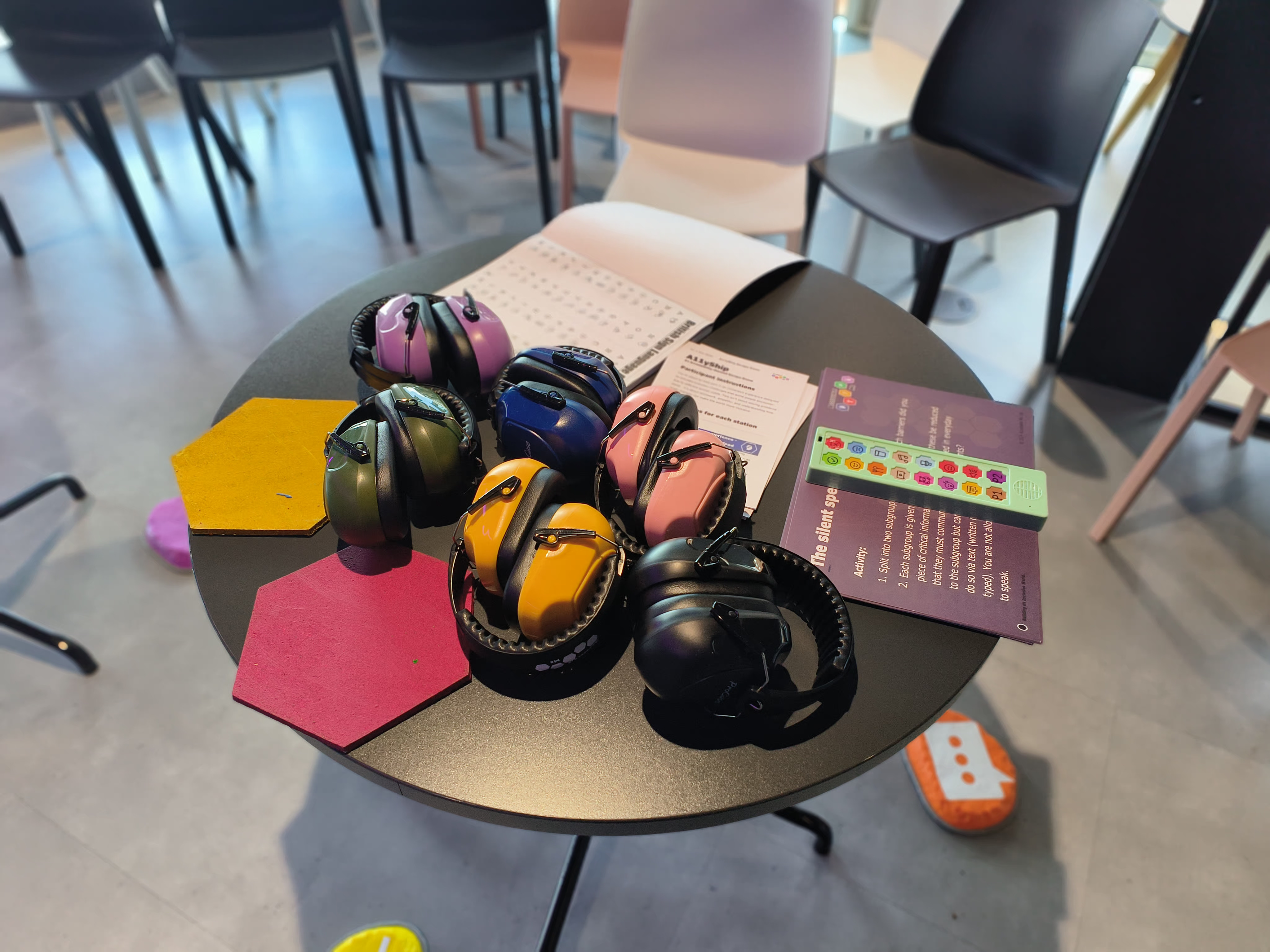 A table with different coloured noise cancelling headphones