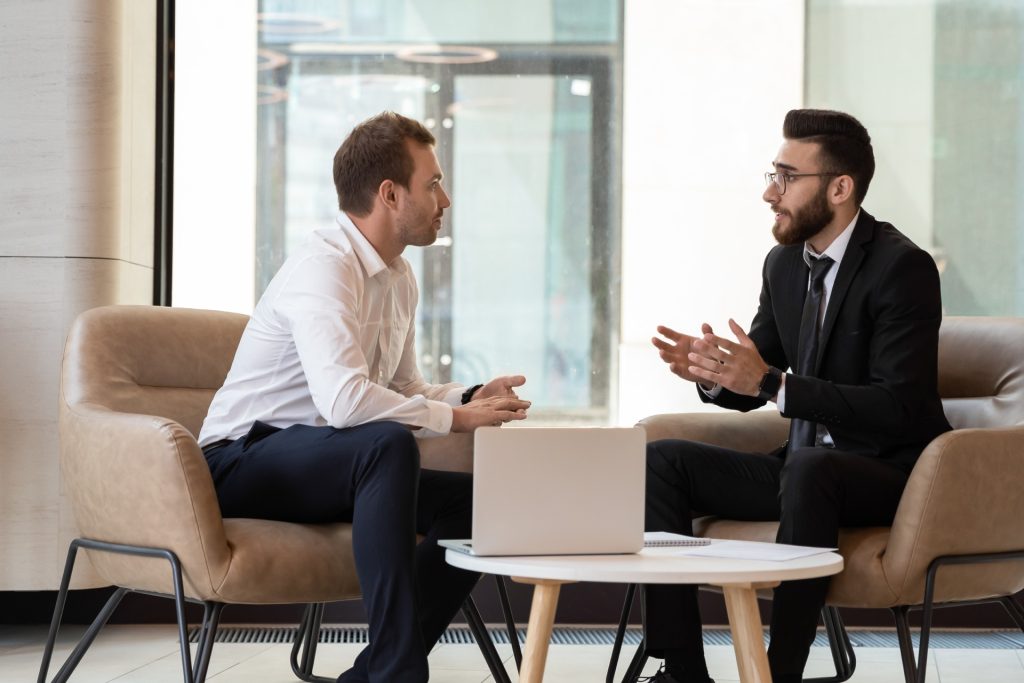 2 professionals holding a conversation while seated