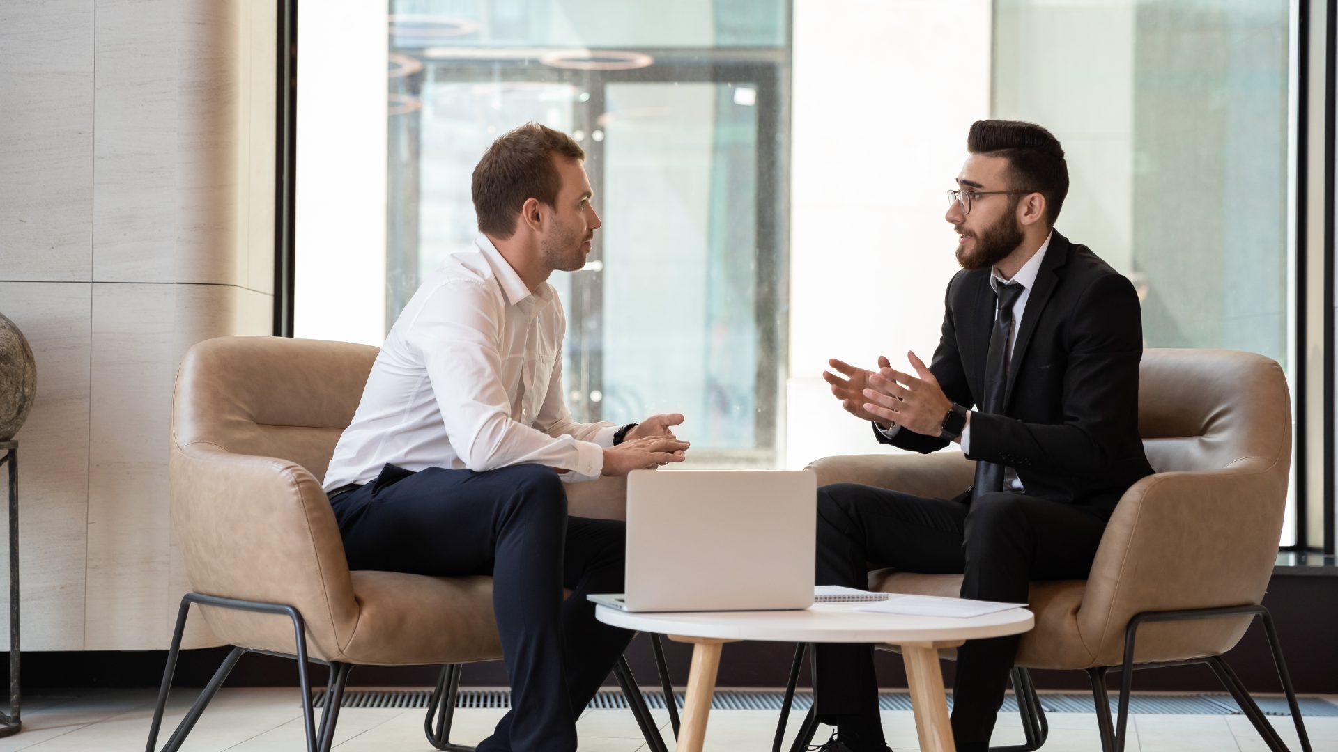 2 professionals holding meeting while seated together